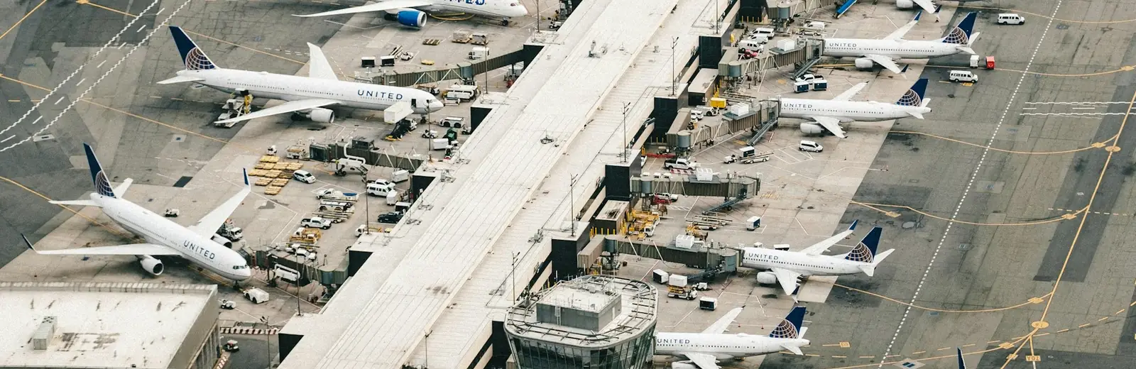 Aerial view of aircraft parked at the gates of an airport terminal