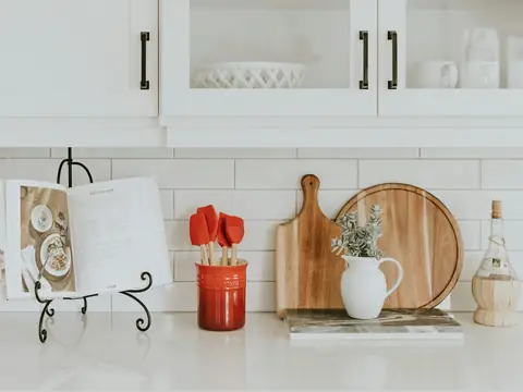Kitchen utensils and cutting boards on a white counter