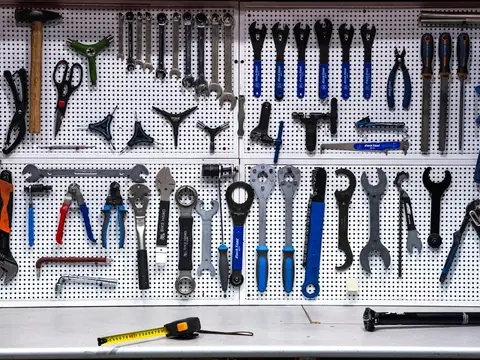 Hand tools hanging on a workshop pegboard