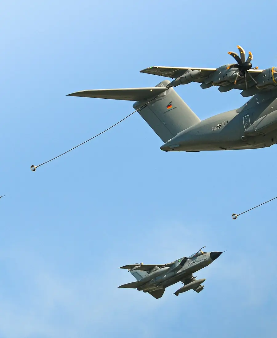 Military transport aircraft flying above two fighter jets